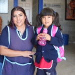 Niños y educadores maristas a la entrada del colegio; acompañamiento cercano y alegre a la infancia, signo de “caminar con los más frágiles