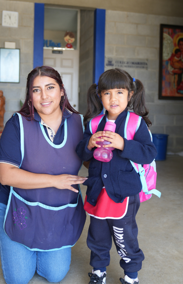 Niños y educadores maristas a la entrada del colegio; acompañamiento cercano y alegre a la infancia, signo de “caminar con los más frágiles