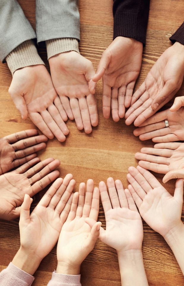 Manos unidas en círculo, gesto de comunidad y solidaridad navideña.
