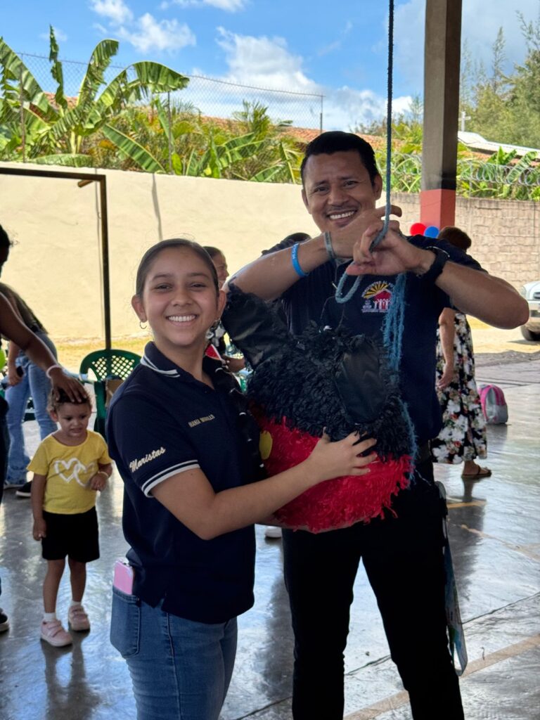 Estudiante del Colegio Marista La Inmaculada sonríe mientras participa en una actividad solidaria junto a un miembro de la comunidad escolar.
